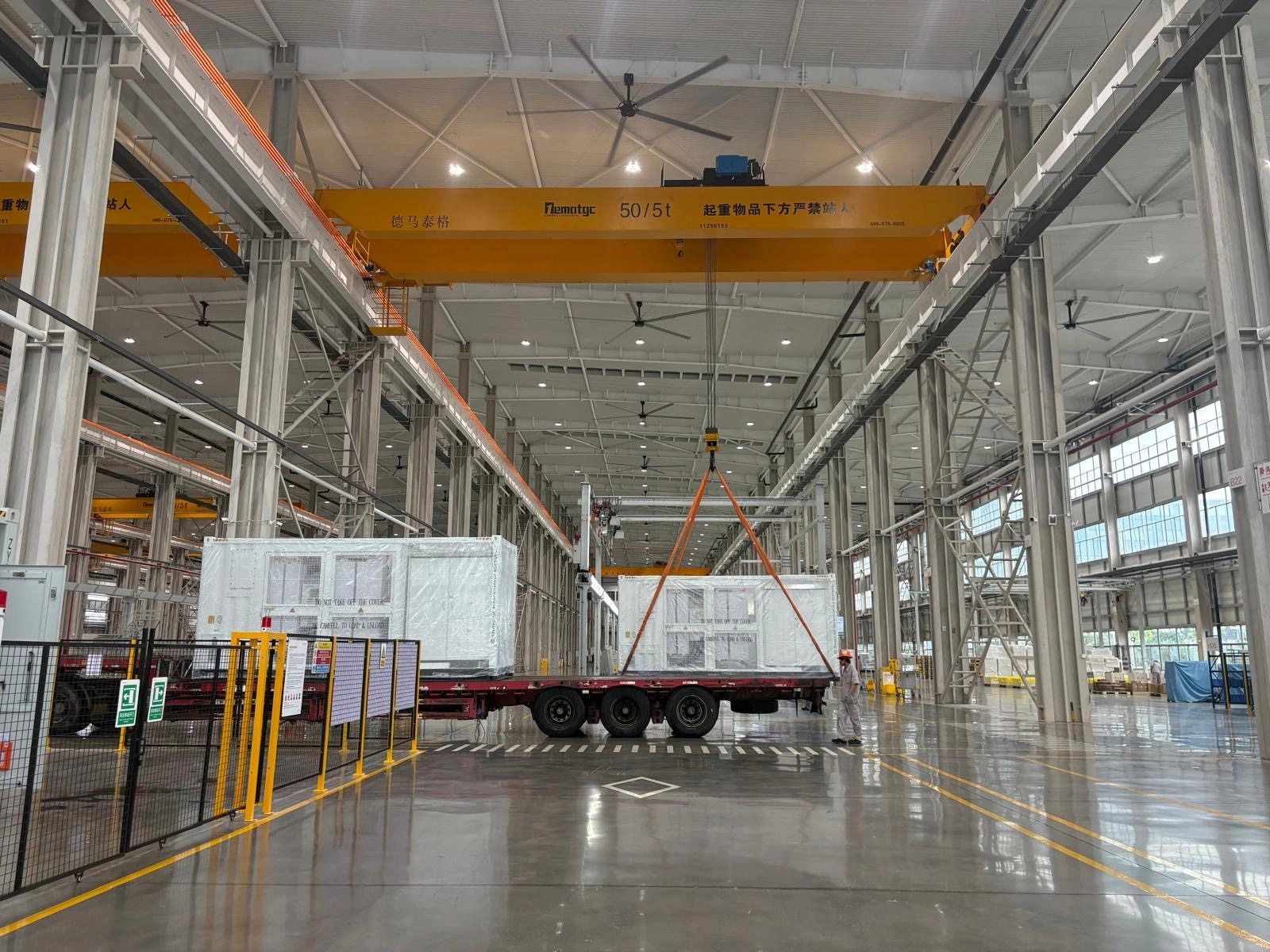 Factory floor with electrical equipment on a trailer beneath an overhead crane