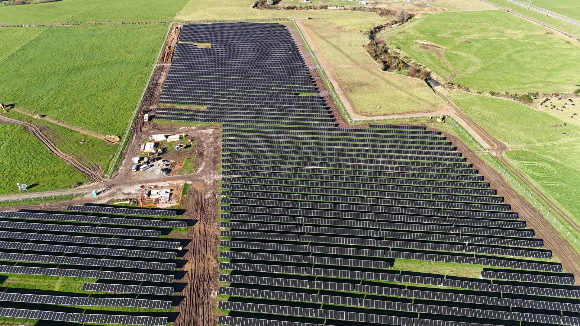 Aerial view of completed solar panel rows and active construction areas at Reefton Solar Farm